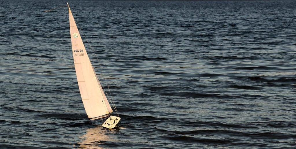 Professionele zeilinstructeur geeft zeillessen aan leerling op het water